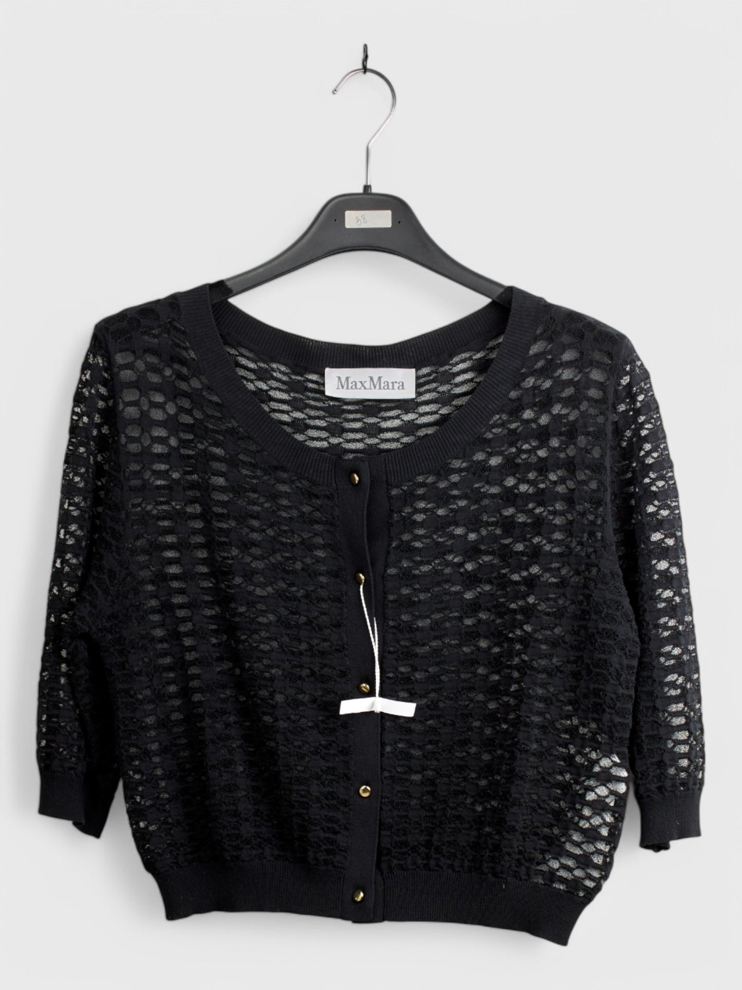 Black knit cardigan with open front and long sleeves, textured pattern, displayed on a hanger with tag, size 44
