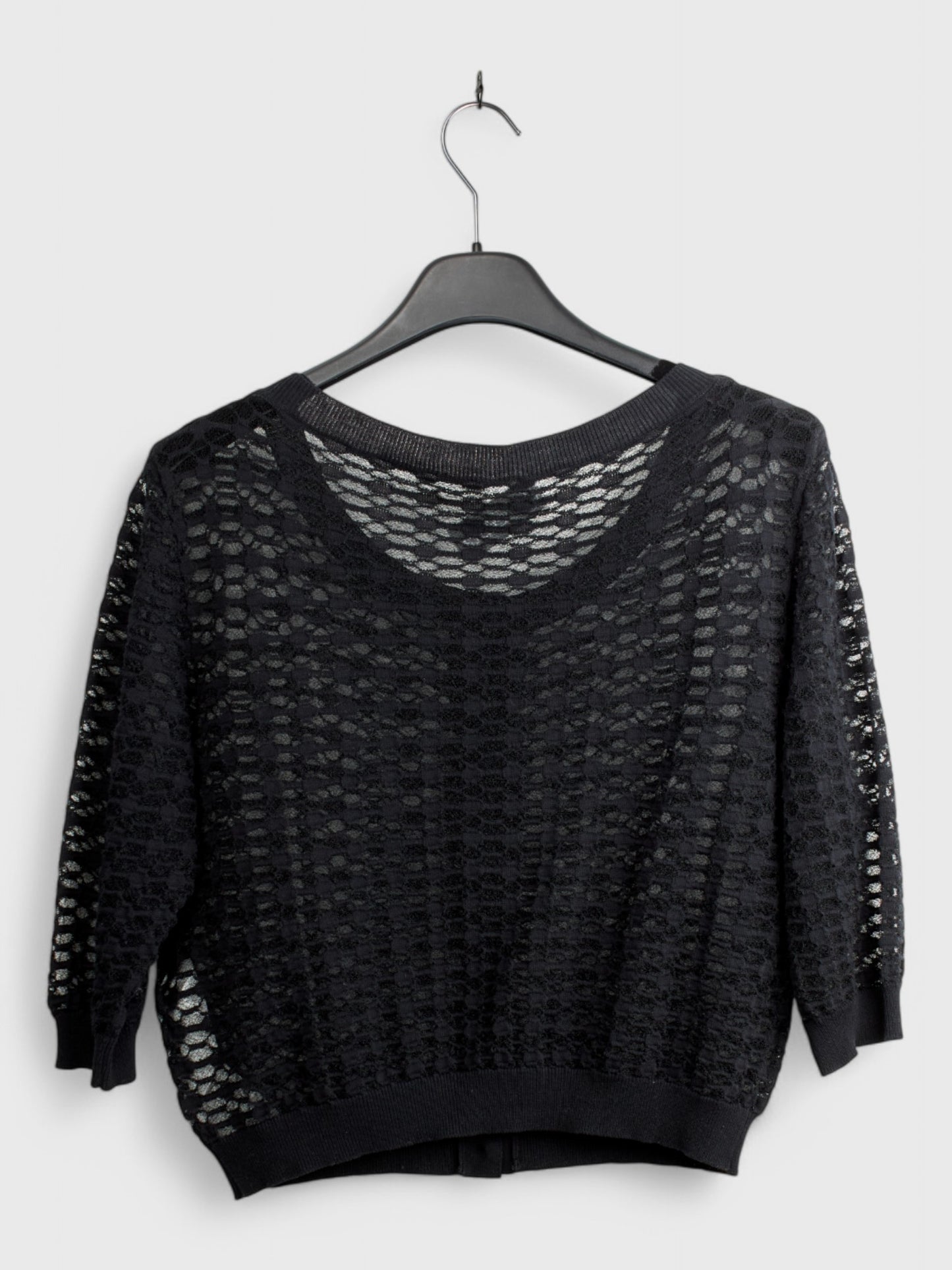 Back view of black knit cardigan with open texture pattern and long sleeves hanging on hanger, size 44