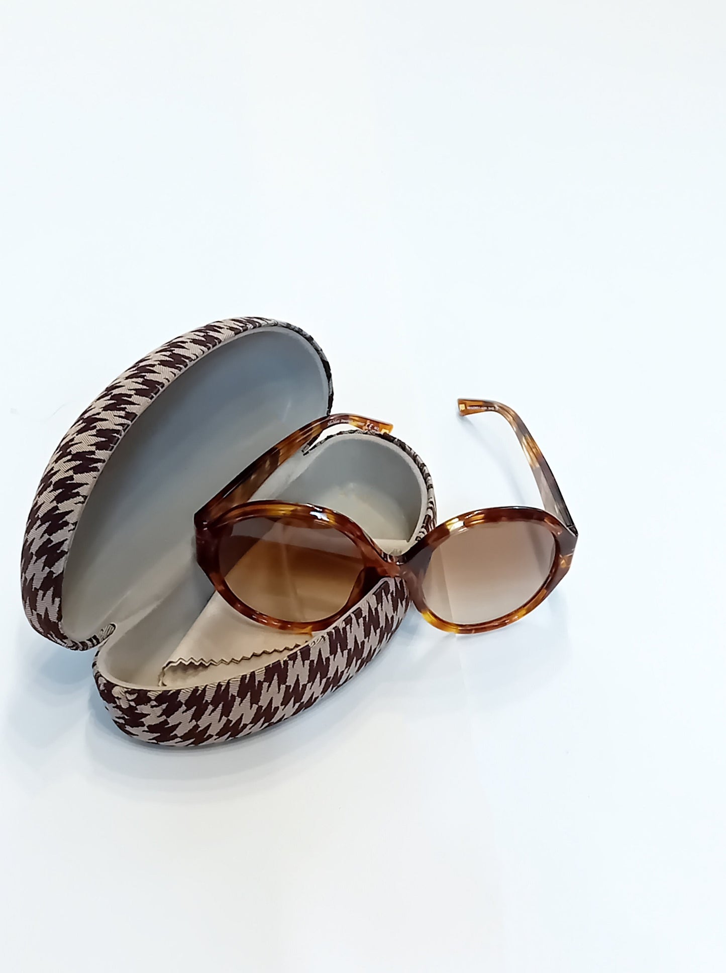 Max Mara sunglasses with brown frames and a patterned case on a white background