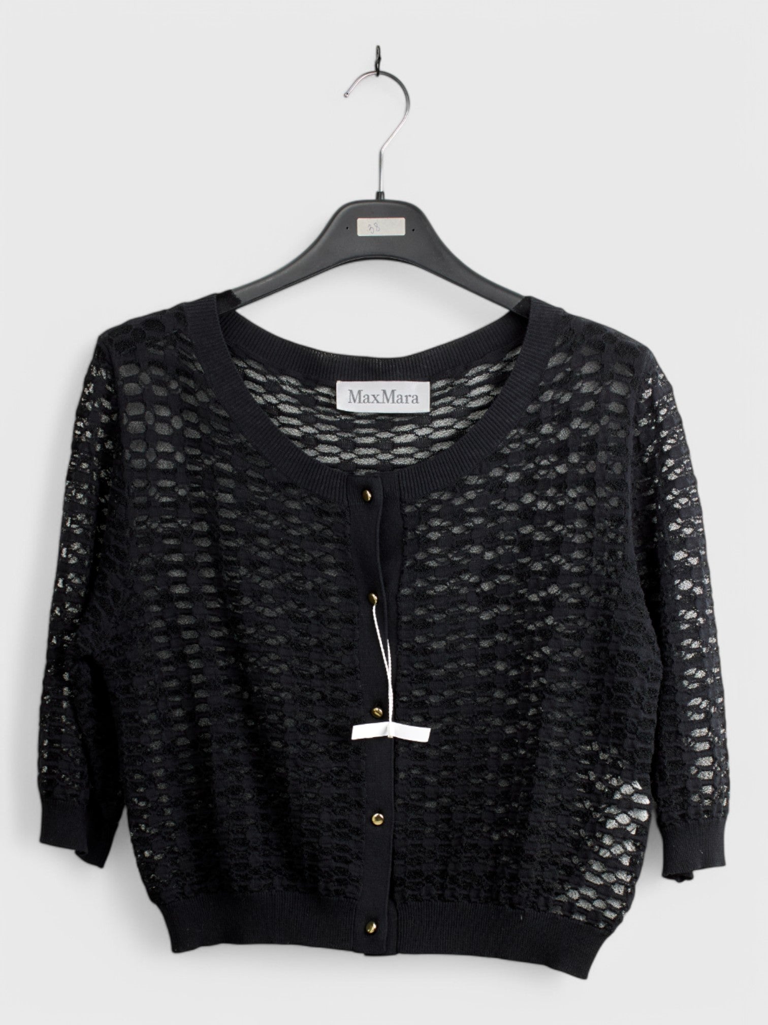 Black knit cardigan with open front and long sleeves, textured pattern, displayed on a hanger with tag, size 44